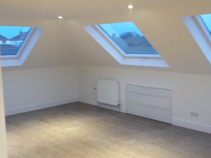 Finished loft room with white walls, skylights and timber floor