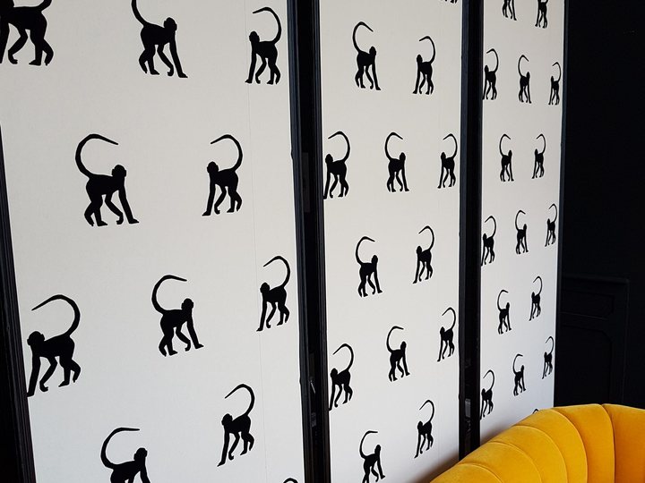 Black and white patterned wallpaper installed on an interior wall