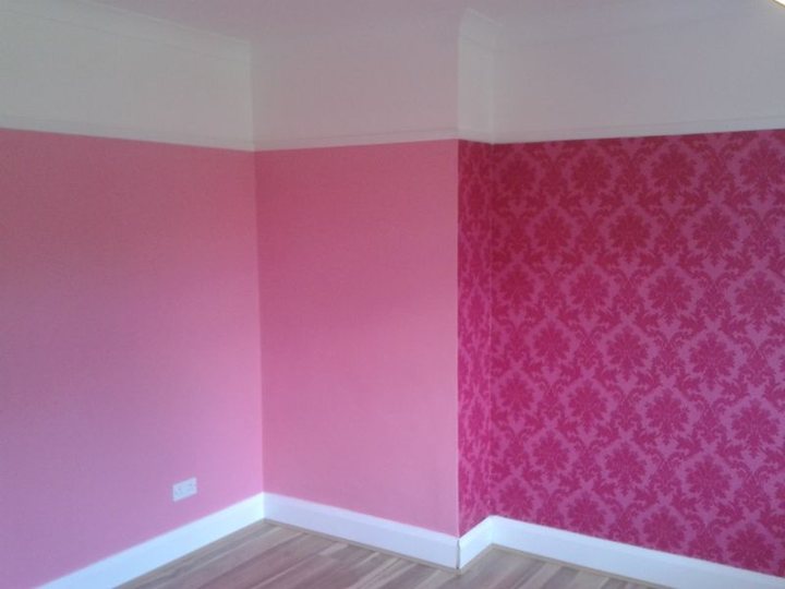Room decorated with pink walls and a patterned feature section