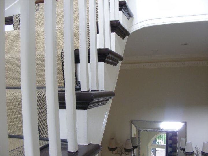 Detailed painted staircase spindles and dark handrail