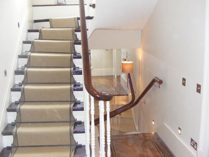 Decorated staircase with white balustrades and dark handrail