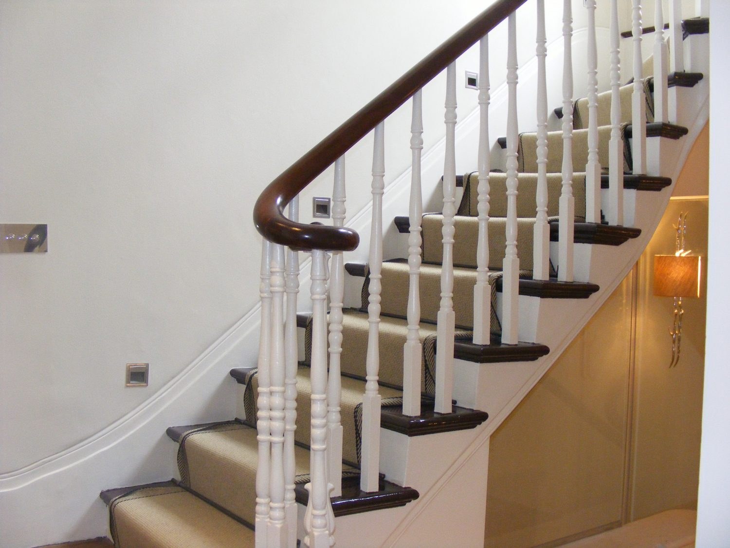 Painted staircase with a dark handrail and light balustrades by Decor-Plast, painter and decorator serving Kensington