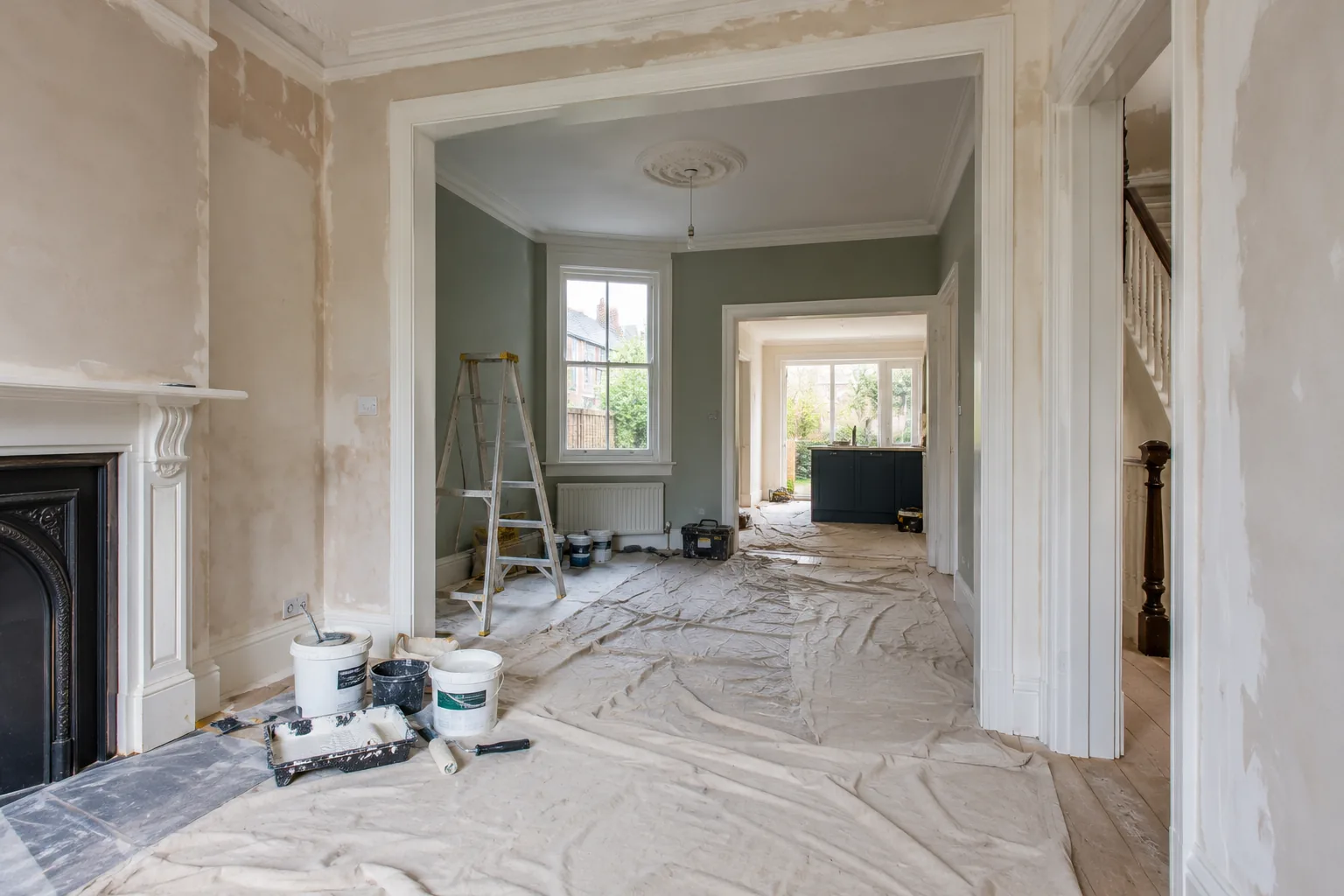 Rooms mid-preparation during a whole-house redecoration, with dust sheets and filled walls
