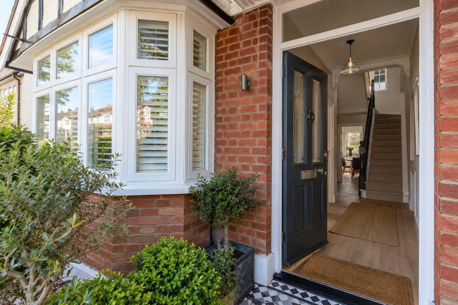 Red-brick house with a white bay window and a dark front door opening onto the hallway, full property redecoration in Croydon